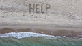 Help written on exotic sand beach with tropic blue sea.