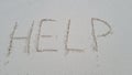 Help written on sandy beach and sea Royalty Free Stock Photo