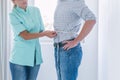 Helpful dietitian measures the patient`s waist circumference during the examination