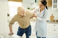 Healthcare worker helping ageed man get up from the chair Royalty Free Stock Photo