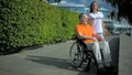 Helpful female volunteer resting with a wheelchaired man