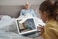 Helpful granddaughter calling medical help for grandma online