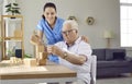 Helpful nurse in retirement home playing games with demented senior male patient