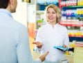 Helpful pharmacist serving and consulting man Royalty Free Stock Photo