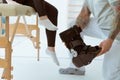 Professional physiotherapist helps the patient to put on an orthosis for the first time