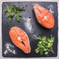 Helpful sports foods, cooking two fresh salmon steak with herbs and spices,on cutting board stone, top view close up Royalty Free Stock Photo