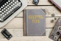 Helpful Tips on old book cover at office desk with vintage items Royalty Free Stock Photo