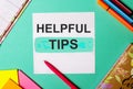 HELPFUL TIPS written on a turquoise background near bright stickers, notepads and markers