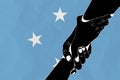 Helping hand against the Federated States of Micronesia flag. The concept of support. Two hands taking each other. A helping hand