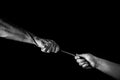 Helping hand concept, hands pulling rope, giving help, care and support, reaching out, saving.