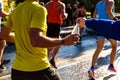 A helping hand delivers a bottle of water to a runner in a running race for him to drink