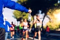 A helping hand delivers a bottle of water to a runner in a running race for him to drink