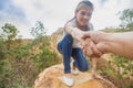 Helping hand - hiker woman getting help on hike smiling happy overcoming obstacle. Tourist walking on the Mountain, Young couple Royalty Free Stock Photo