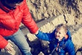 Helping hand- little boy helped by father in mountains Royalty Free Stock Photo