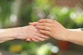 Young caregiver holding seniors hands. Helping hands, care for the elderly concept Royalty Free Stock Photo