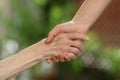 Young caregiver holding seniors hands. Helping hands, care for the elderly concept Royalty Free Stock Photo