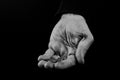 Helping hands concept, Rich giving the poor, Man`s hands palms up holding money coins, reaching out, black and white Royalty Free Stock Photo