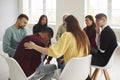 Diverse people supporting and comforting crying young man in group therapy session Royalty Free Stock Photo