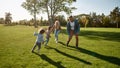 Helping parents rest. Excited family running outdoors on a sunny day Royalty Free Stock Photo