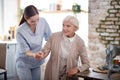 Caregiver smiling while helping aged woman to walk Royalty Free Stock Photo