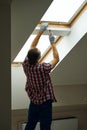 Helping you to fix it. Rear view of handyman using screwdriver while fixing or installing a window in a new dry wall Royalty Free Stock Photo