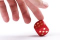 Helping your luck, cheating in games, dishonesty concept. A human finger pushing over a dice to make it show a six