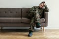 Helpless soldier sitting on a couch while waiting for a therapy session