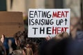 Demonstrator carrying sign Eating meat is rising up the heat