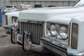 Classic american Cadillac car in store parking. Front detail of white luxury retro vintage automobile headlight Royalty Free Stock Photo