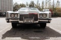 Classic american Cadillac car in store parking. White luxury retro vintage automobile. Front view in low perspective Royalty Free Stock Photo