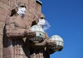 Stone statues at the Helsinki Railway Station wearing protective masks