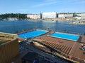 Helsinki, Finland - August 29, 2017: People bathe in an open public pool against the backdrop of the seaport and city buildings Royalty Free Stock Photo