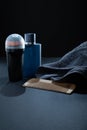 Closeup of men\'s toilet accessories. A deodorant, an Eau de toilette fragrance bottle, a beard brush, and a towel.