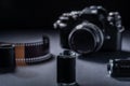 Closeup of vintage 35mm SLR-type film camera, and old metallic film cartridge against a dark background Royalty Free Stock Photo