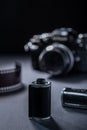 Closeup of vintage 35mm SLR-type film camera, and old metallic film cartridge against a dark background Royalty Free Stock Photo