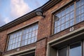 A closeup detail of an old red brick building with retro style small windows. A metallic lamppost and numbers 44 and 45 on the Royalty Free Stock Photo