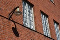 A vintage gas powered lamppost hanging on a red brick wall