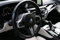 Close up white leather cockpit, steering wheel and dashboard BMW 650i 2019 in white leather car interior. Modern Car interior deta