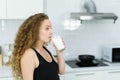 helthy beautiful woman drinking milk, look at space in kitchen. Royalty Free Stock Photo