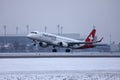 Helvetic Airways plane taking off from Munich Airport, MUC, snow Royalty Free Stock Photo