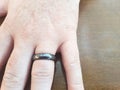 Hematite ring or band on a man\'s finger.