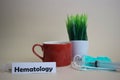 Hematology text, grass pot, coffee cup, syringe, and face green mask.