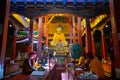 View of Lord Buddha statue in the main temple hall, with prayer session in progress, Hemis Monastery, Ladakh, India