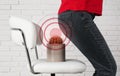 Hemorrhoid concept. Woman sitting down on chair with cactus near brick wall, closeup