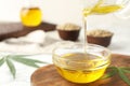 Hemp oil pouring from sauce boat into bowl Royalty Free Stock Photo