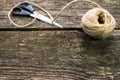 Hemp rope and scissor on old aged weathered pine wood background
