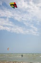 Henichesk, Ukraine - July 12, 2021: Kitesurfing. Seascape with kitesurfer in waves. Surfer in wetsuit doing trick in air against