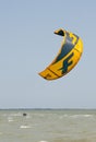 Henichesk, Ukraine - July 12, 2021: Surfer in wetsuit do trick. Kitesurfing athlete on kite board. Foiling kiteboarding