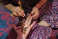 Henna art: local girl painting hands with black traditional color in an Indian house Royalty Free Stock Photo