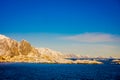 Henningsvaer, Norway - April 09, 2018: Beautiful above view of wooden buildings with huge mountaing behind in